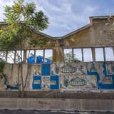 La Fibronit, la �fabbrica della morte� � circondata da piante altissime lasciate crescere selvaggiamente dopo la chiusura dell�impianto avvenuta nel 1985. Sui muri esterni sono ancora attaccati dei vecchi manifesti di un circo